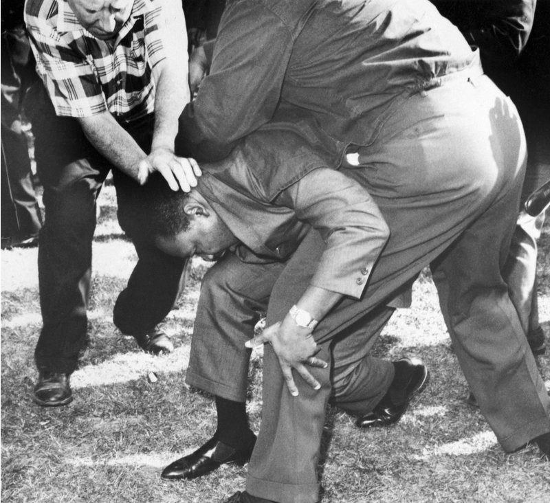 Struck on the head by a rock thrown by a group of hecklers, MLK falls to one knee | Credit: Bettmann/Getty Images