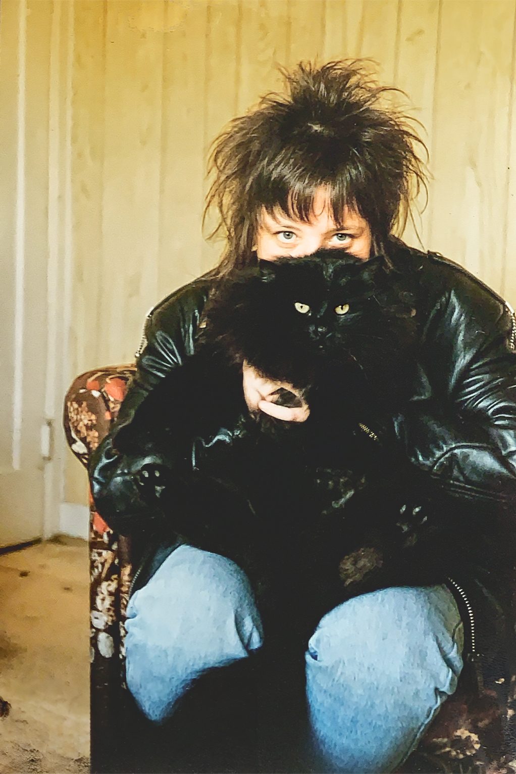 A woman holding a black cat